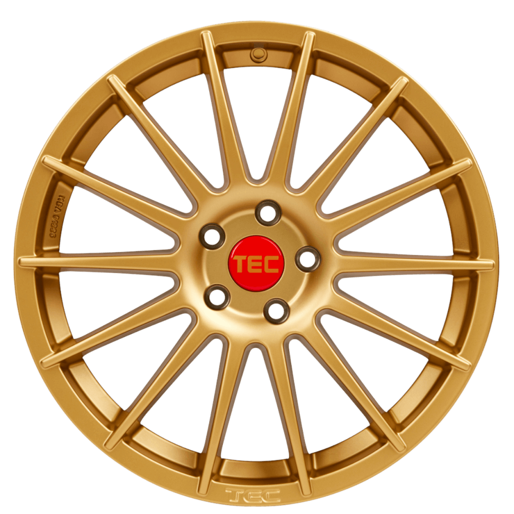 Goldene mehrspeichige Alufelge mit roter TEC-Nabenkappe auf weißem Hintergrund