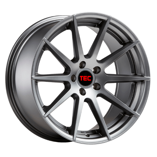 Eine silberne Leichtmetallfelge mit zehn Speichen und schwarzer Nabenkappe mit rotem TEC-Schriftzug auf weißem Hintergrund